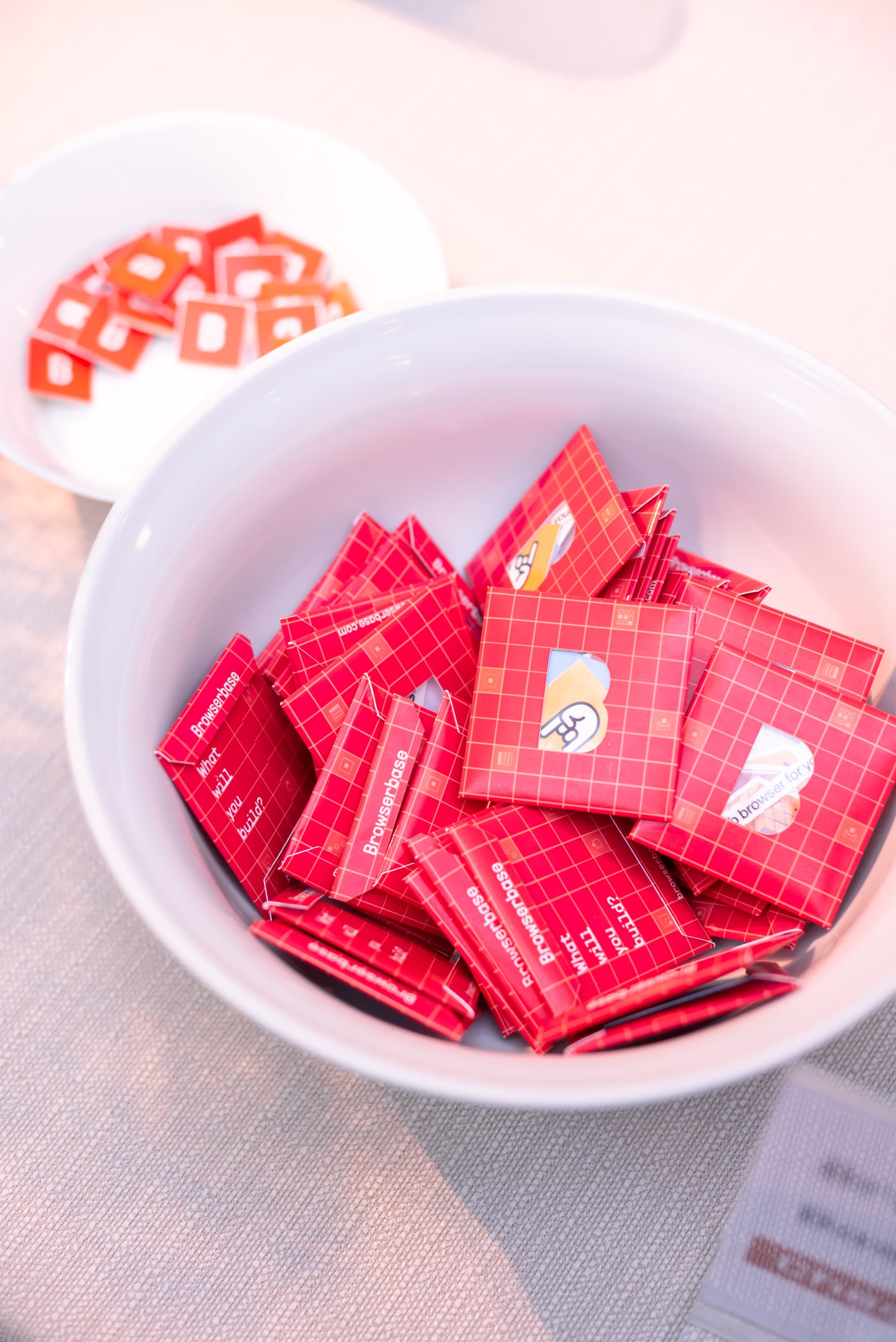 Bowl of red branded Browserbase chocolate squares as party favors